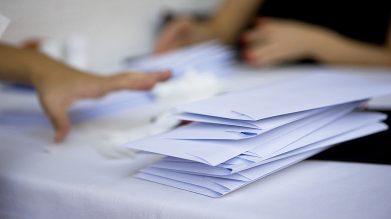 Stack of letters with two people in background