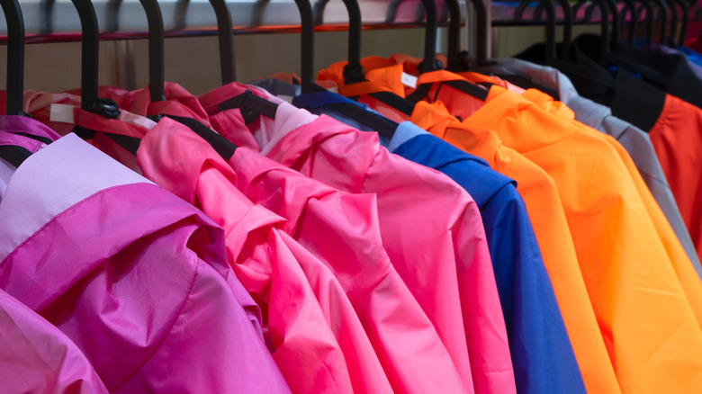 Colorful rain jackets on hangers in closet