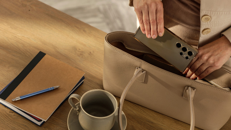 Woman placing phone inside purse