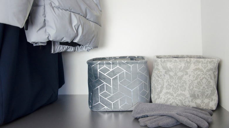 Fabric storage bins in closet with gloves next to them