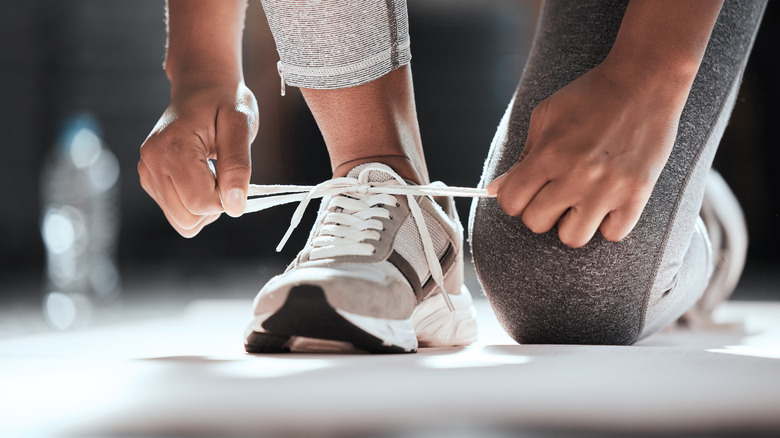 Person tying laces on running shoes