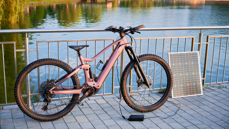 Close up of pink electric bike charging on deck