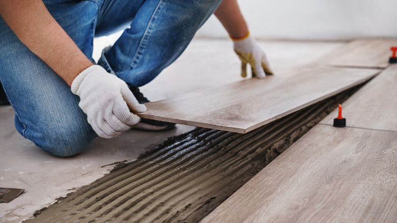 Man laying tiles on floor