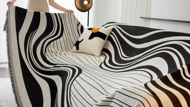Woman putting a striped cover on a couch