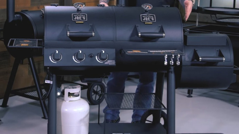 Man demonstrates the Oklahoma Joe's canyon combo charcoal/gas smoker & grill