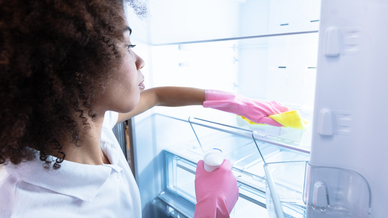 woman cleaning inside fridge