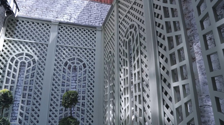 Intricate latticework in a muted green grey color in a terrace.