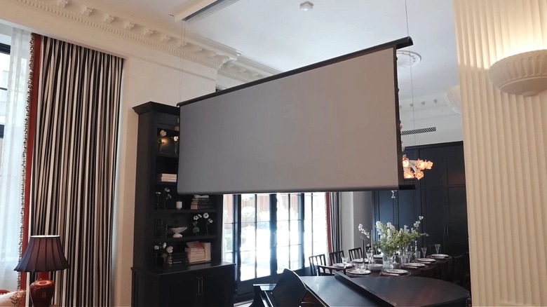 A projector screen drops from the ceiling.