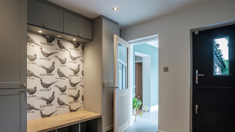 Mudroom with a wallpapered accent wall