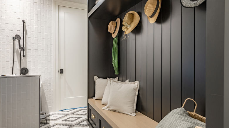 Tidy small mudroom with black wood panelling