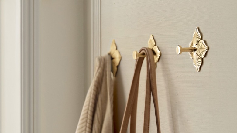 Gold floral wall hooks on mudroom wall