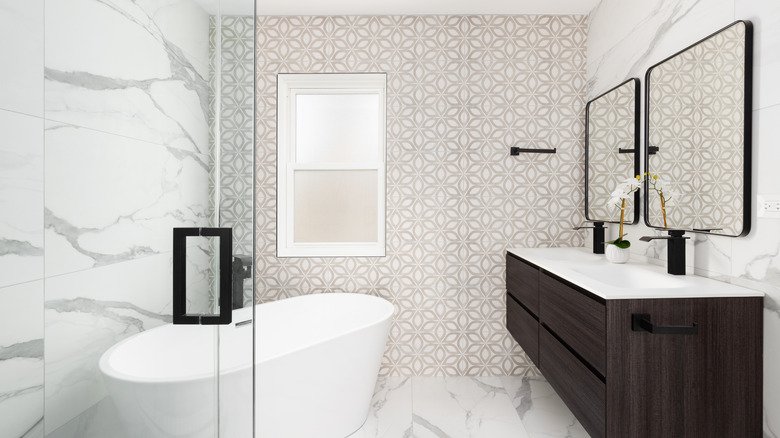 Beige and white patterned tile accent wall in a bathroom