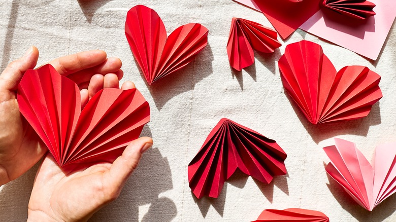 Hands holding folded paper hearts