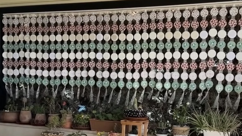 Curtains made of jar lids hanging outdoors