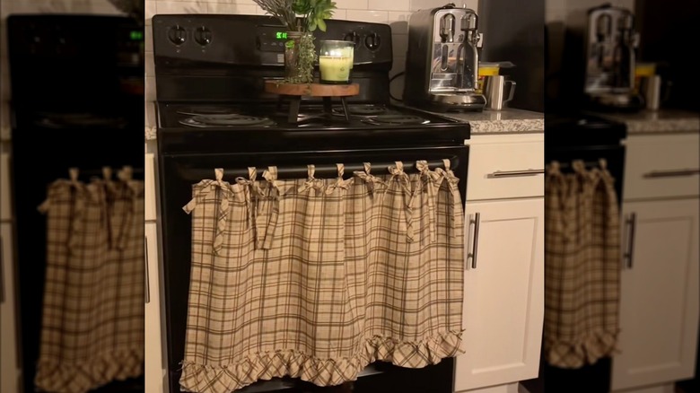 A DIY oven curtain made from patterned fabric and hung with matching ribbons