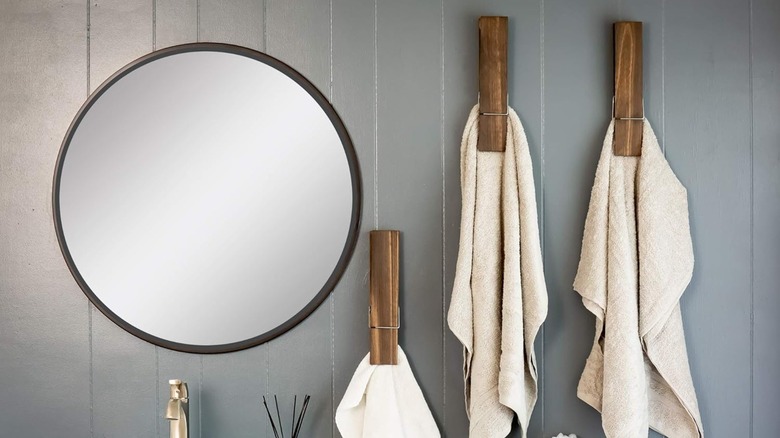 Towels hang from oversized clothespins in a bathroom.