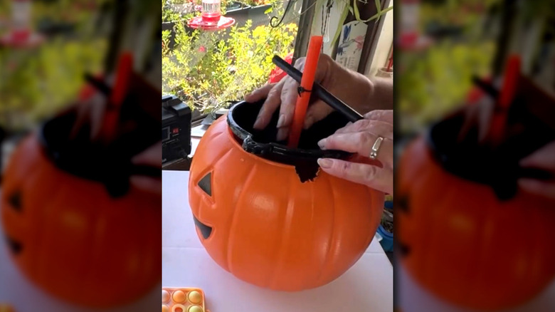 demonstrator adding funnel, nozzle attachment, and straw to bucket for design process