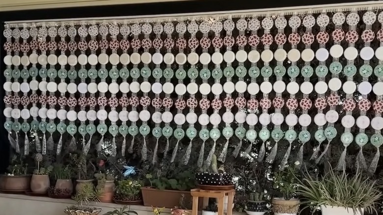 Curtains made of jar lids hanging outdoors
