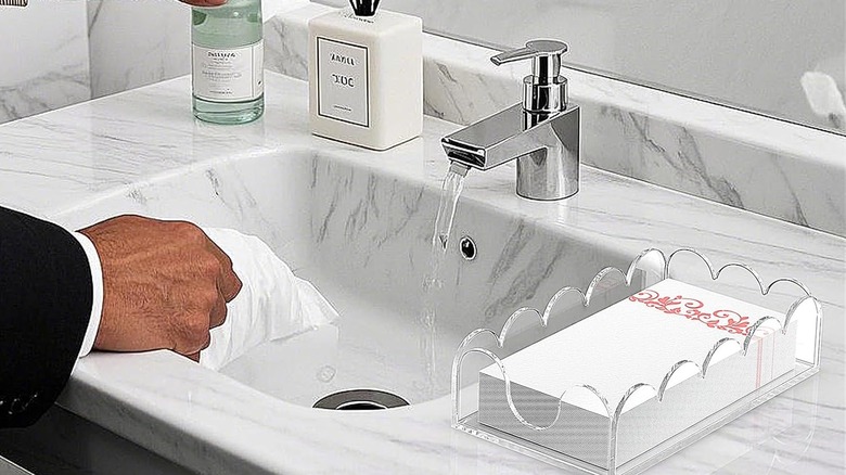 Paper napkins in napkin holder next to bathroom sink