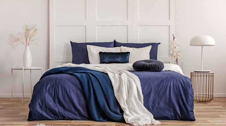 A modern bedroom with navy blue bedding.