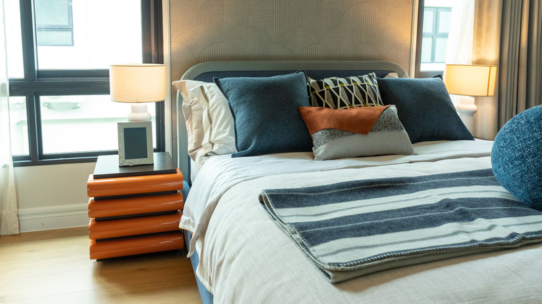 A modern bedroom with blue and orange.
