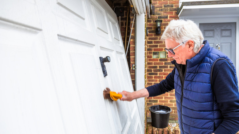 An older man cleaning his garage door