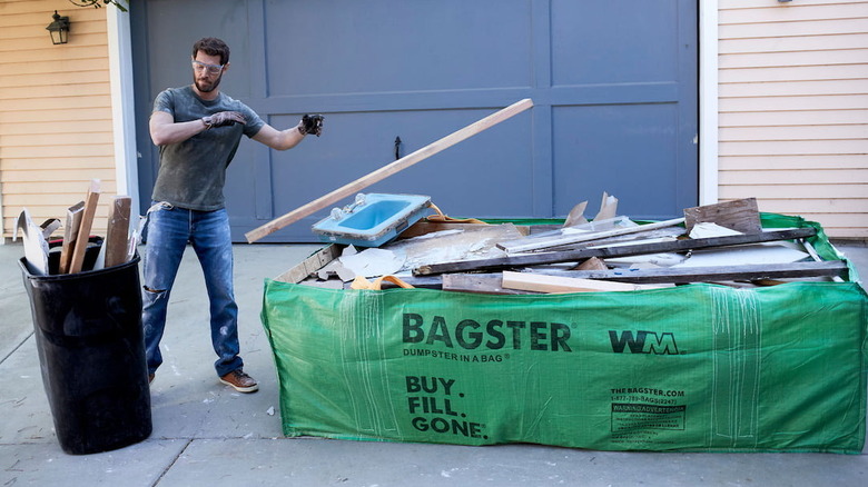Man throwing renovation junk into a Bagster bag