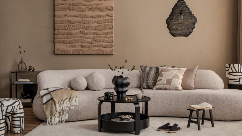 A brown living room with a white couch and brown decor