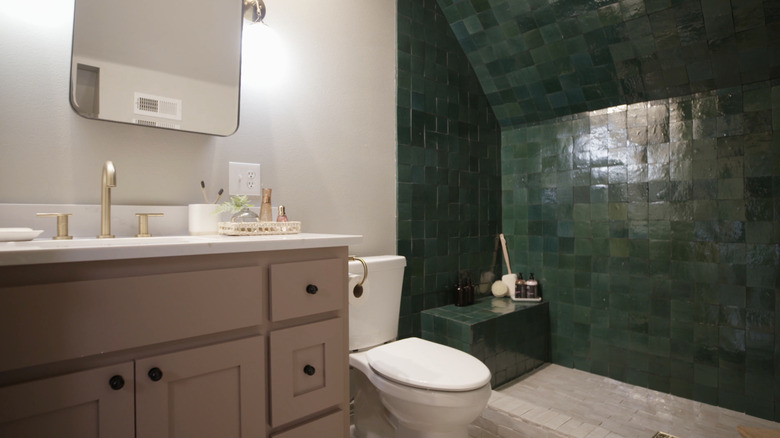 pink vanity with green tiled shower