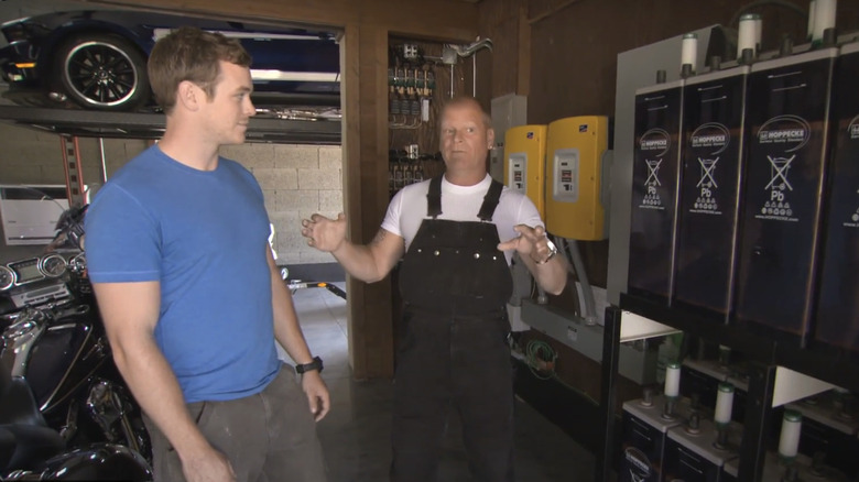 Mike Holmes and Mike Jr. in a garage.
