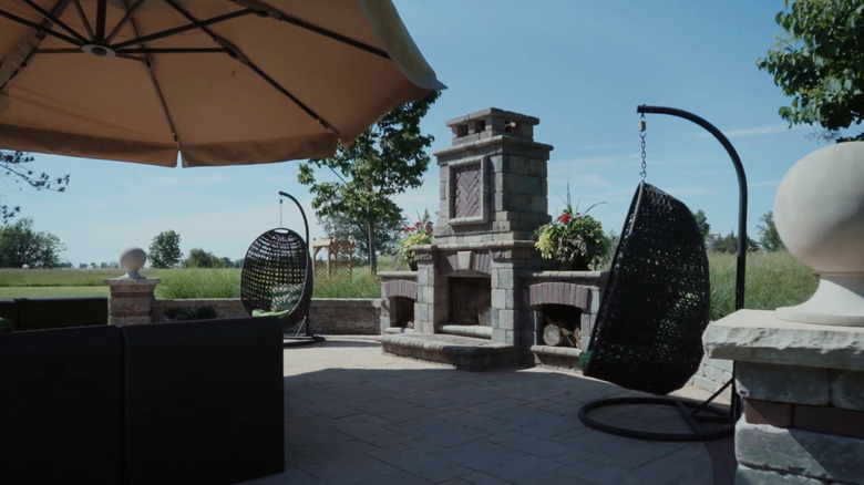 A backyard fire pit and swinging chairs.