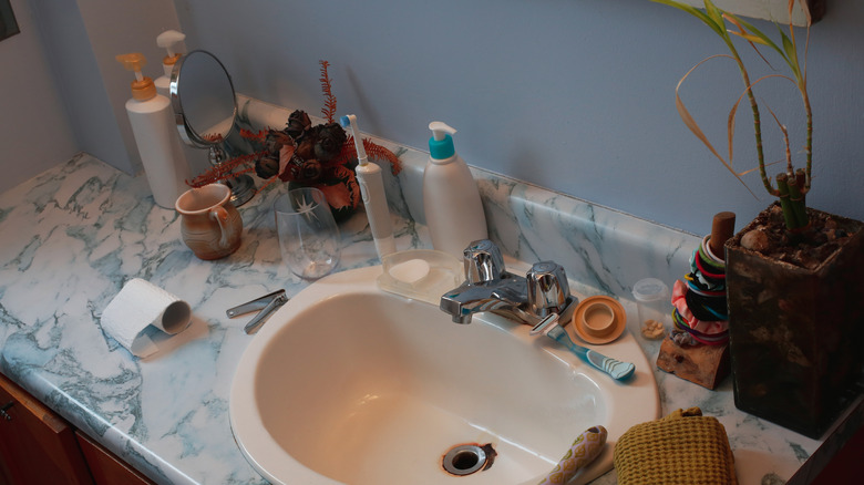 A cluttered bathroom countertop.