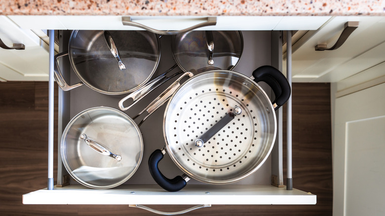 Saucepans in a drawer as seen from above.