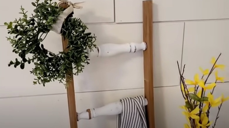 Ladder made from spindles leaving on a wall with decor