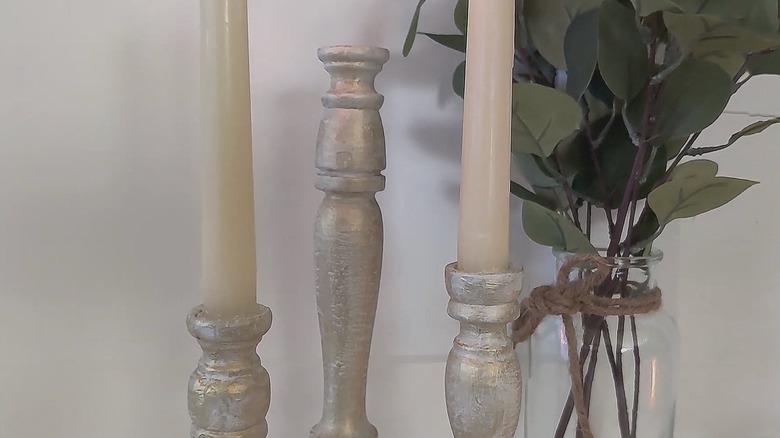 Three spindle candlesticks with taper candles and eucalyptus