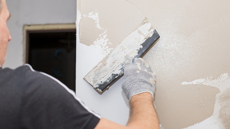 Person spackle painting a wall