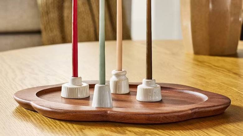 A set of candles placed on Hearth & Hand's Small Wood Scallop Oval Tray.