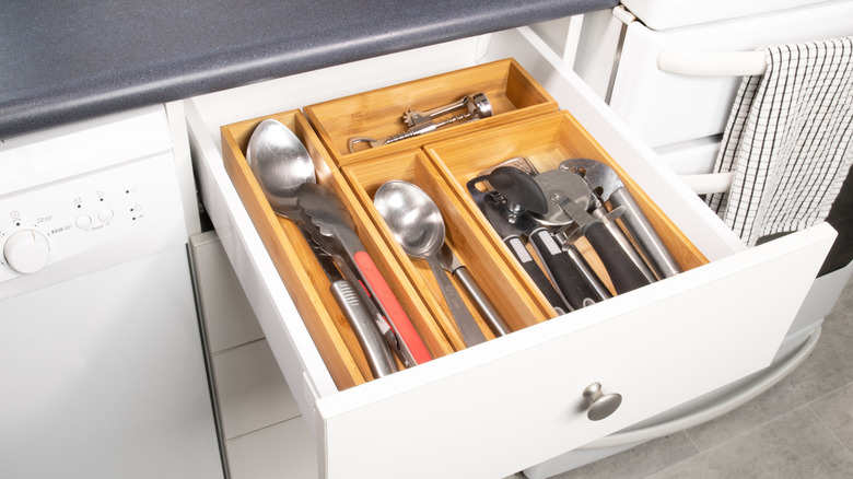 Neatly packed silverware and utensils in a bamboo drawer organizer