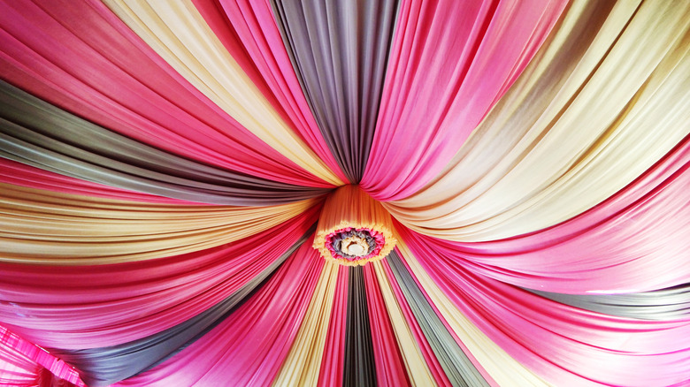 Colorful draped fabric hangs from ceiling