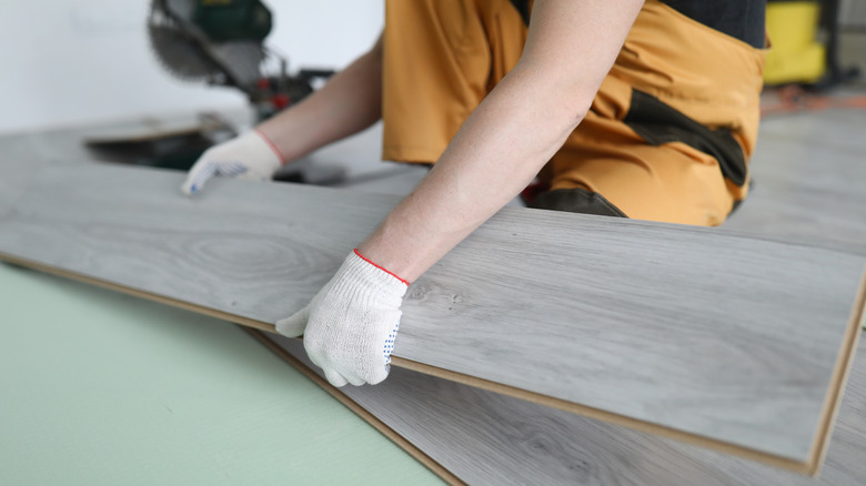 Person replacing laminate flooring