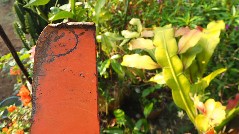 A person holding a bent lawn mower blade