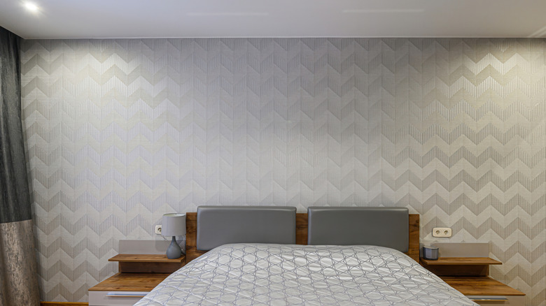 A bedroom with a chevron patterned accent wall.