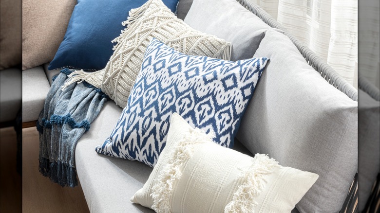 An ikat throw pillow with other accent pillows on a couch.