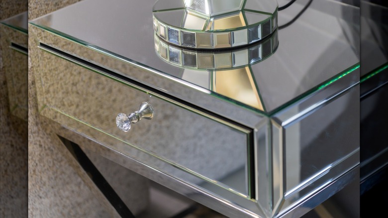 A close up of a mirrored nightstand