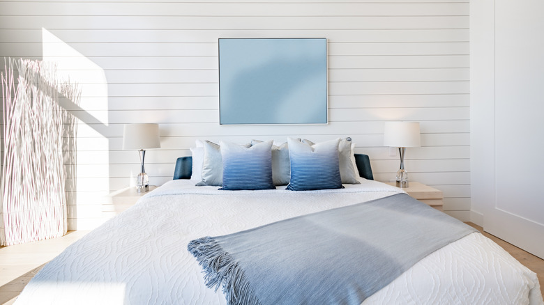 A bedroom with a shiplap accent wall.