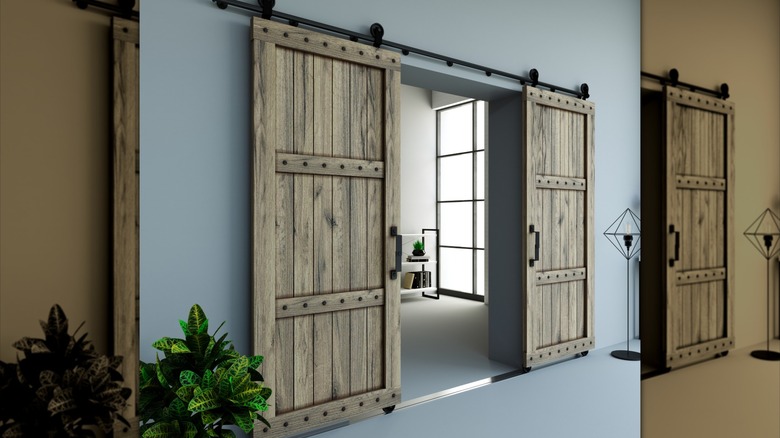 A set of sliding barn doors in a room with gray walls.