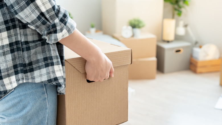 Person holding a box preparing to move
