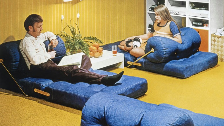 Image from a 1970s IKEA catalogue of a father and daughter lounging on denim cushions.