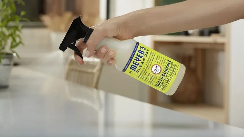Spraying Mrs. Meyer's Clean Day All-Purpose Cleaner on white countertop