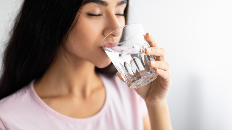 Woman holding glass of water